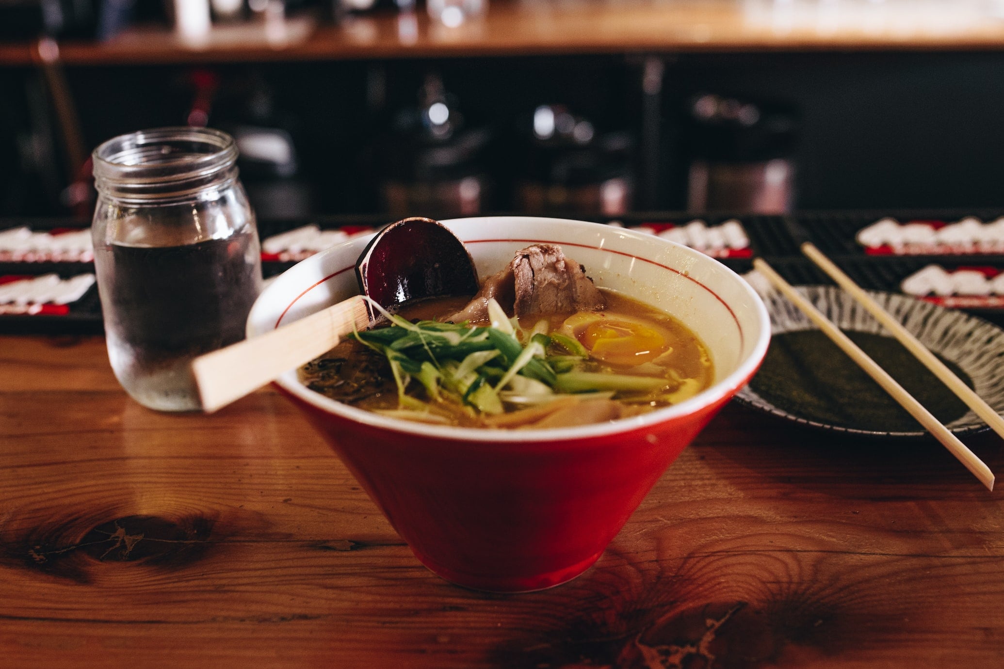 Tom Yum Soup in a bowl surrounded by various utensils