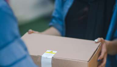 A woman accepting her delivery from a courier.