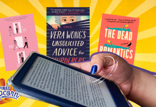 Reader holding a Kindle surrounded by books