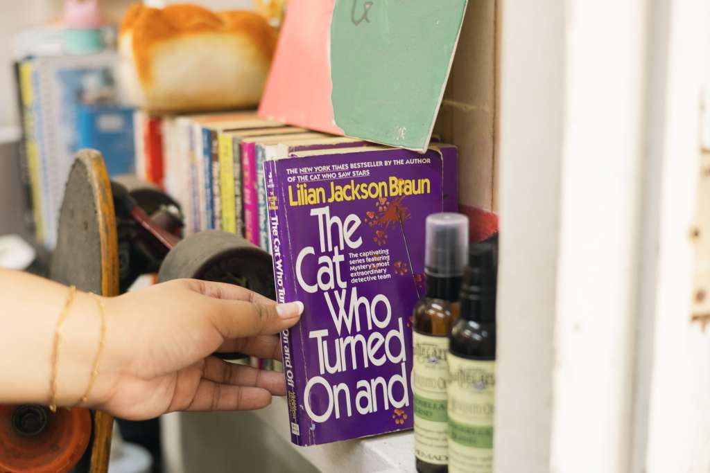 Hand reaching out for a book on a shelf