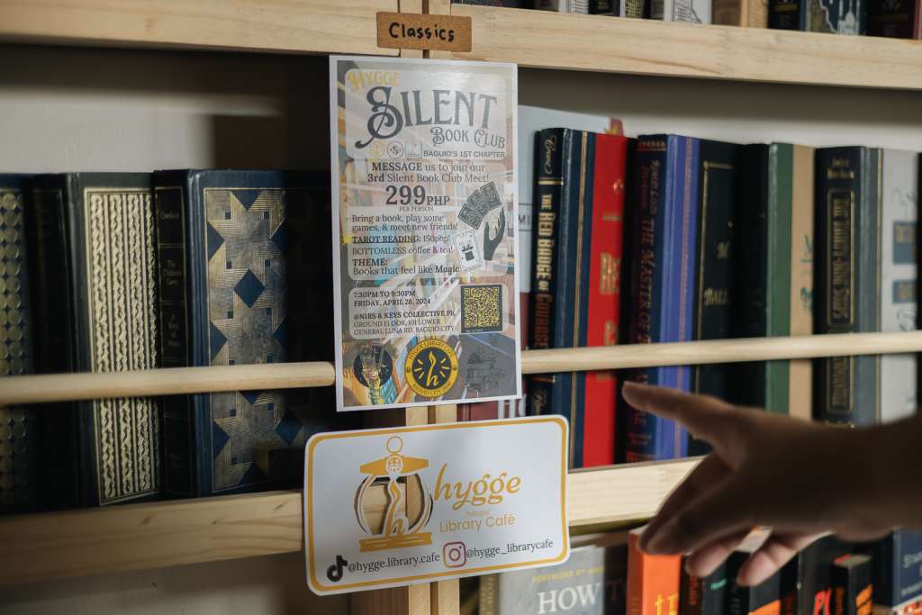 Hand pointing at a notice on a bookshelf